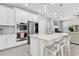 Modern kitchen boasts white cabinets, stainless steel appliances, quartz countertops, and pendant lighting at 12382 Tibbetts St, Odessa, FL 33556