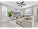 Living room with an entertainment center, sectional sofa, large windows and tile floors at 12382 Tibbetts St, Odessa, FL 33556