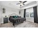 Stylish bedroom with a dark-themed bed, tray ceiling, and natural light from the window at 12382 Tibbetts St, Odessa, FL 33556