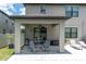 Covered patio area with seating, ceiling fan, and sliding glass door access to the home at 12382 Tibbetts St, Odessa, FL 33556