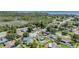 An aerial view showcases a neighborhood with mature trees and waterfront views in the distance at 1304 Cedar Ct, Tarpon Springs, FL 34689