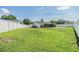 Expansive fenced-in backyard featuring lush green grass and a screened-in lanai with a pool at 1304 Cedar Ct, Tarpon Springs, FL 34689
