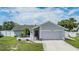 Charming single-story home featuring a two-car garage, light stone facade, and a well-kept front lawn at 1304 Cedar Ct, Tarpon Springs, FL 34689