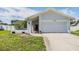 Charming single-story home showcasing a well-maintained front yard and a two-car garage at 1304 Cedar Ct, Tarpon Springs, FL 34689