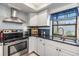 Well-lit kitchen featuring white cabinets, stainless steel appliances, and a dark countertop at 1304 Cedar Ct, Tarpon Springs, FL 34689