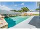 Sparkling pool surrounded by a well-manicured yard and privacy fence at 1304 Cedar Ct, Tarpon Springs, FL 34689
