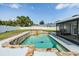 Backyard oasis featuring a sparkling pool with stone accents and lush landscaping at 1304 Cedar Ct, Tarpon Springs, FL 34689