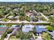 Wide aerial perspective showcases a residential area with lush greenery, pools, and diverse home styles at 13186 Linden Place Dr, Seminole, FL 33776