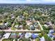 A wide aerial shot displays a residential area with well-maintained homes, pools, and tree-lined streets at 13186 Linden Place Dr, Seminole, FL 33776