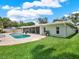 Expansive backyard with a private pool, screened lanai, and lush green lawn, perfect for outdoor living at 13186 Linden Place Dr, Seminole, FL 33776