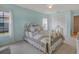 Charming bedroom with a white iron bed frame, floral bedding, and a view of the outdoors at 13186 Linden Place Dr, Seminole, FL 33776