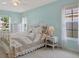 Bright bedroom featuring a white metal bed frame, ceiling fan, and a window with natural light at 13186 Linden Place Dr, Seminole, FL 33776