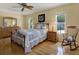 Cozy bedroom with wood floors, a comfortable bed, and natural lighting at 13186 Linden Place Dr, Seminole, FL 33776