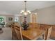 Elegant dining room featuring a wooden table set and classic chandelier, with an open view to the living room at 13186 Linden Place Dr, Seminole, FL 33776