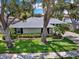 Charming single-story home with mature trees, well-maintained landscaping, and a welcoming facade at 13186 Linden Place Dr, Seminole, FL 33776
