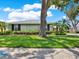 Lovely single-story home with beautiful landscaping, well-manicured lawn, and mature trees at 13186 Linden Place Dr, Seminole, FL 33776
