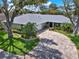 Charming one-story home with lush landscaping, a brick driveway, and mature trees at 13186 Linden Place Dr, Seminole, FL 33776