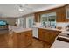 Charming kitchen with wood cabinets, island, white counters, and a view to the pool area at 13186 Linden Place Dr, Seminole, FL 33776