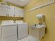 Functional laundry room featuring a washer, dryer, sink, cabinets and storage solutions at 13186 Linden Place Dr, Seminole, FL 33776