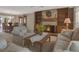 Bright living room with a brick fireplace, built-in shelves, and dining area in the background at 13186 Linden Place Dr, Seminole, FL 33776