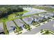 Aerial view of modern homes, showcasing well-manicured lawns and a scenic pond in a desirable residential neighborhood at 13648 Whiskey Daisy Dr, Dade City, FL 33525