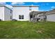 Backyard with well-maintained lawn and wooden pergola with seating and grill at 13648 Whiskey Daisy Dr, Dade City, FL 33525