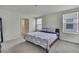 Well-lit bedroom with neutral walls, a bed with a decorative blue and white patterned cover and an ensuite bathroom at 13648 Whiskey Daisy Dr, Dade City, FL 33525