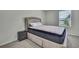 Bedroom with a modern bed, grey nightstand and natural light from the window at 13648 Whiskey Daisy Dr, Dade City, FL 33525