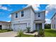 Two-story home featuring a manicured lawn, a two-car garage, and updated trim at 13648 Whiskey Daisy Dr, Dade City, FL 33525