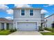 Charming two-story home with a well-maintained lawn and a two-car garage at 13648 Whiskey Daisy Dr, Dade City, FL 33525