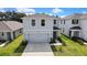 Two-story home with manicured lawn, gray exterior, and convenient two-car garage at 13648 Whiskey Daisy Dr, Dade City, FL 33525