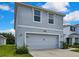 Two-story home with a two-car garage, attractive landscaping, and gray exterior at 13648 Whiskey Daisy Dr, Dade City, FL 33525