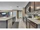 Spacious kitchen with stainless steel appliances, dark cabinetry, granite countertops, and tile floors at 13648 Whiskey Daisy Dr, Dade City, FL 33525