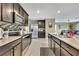 Open kitchen with dark wood cabinetry, stainless appliances, tile backsplash, and granite countertops at 13648 Whiskey Daisy Dr, Dade City, FL 33525