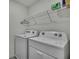 Laundry room with side-by-side washer and dryer and wire rack for storage at 13648 Whiskey Daisy Dr, Dade City, FL 33525