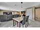 View of the open-concept living space leading to the kitchen with a marble table and dark-stained wood finishes at 13648 Whiskey Daisy Dr, Dade City, FL 33525