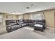 Cozy living room with plush carpeting and a comfortable, oversized leather sectional at 13648 Whiskey Daisy Dr, Dade City, FL 33525