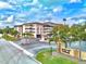 Lovely condo complex with an elegant entrance, circular driveway, and lush landscaping at Port Belleair at 139 Bluff View Dr # 405, Belleair Bluffs, FL 33770