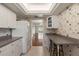 Bright kitchen with tiled floors and white cabinets, next to a breakfast bar at 139 Bluff View Dr # 405, Belleair Bluffs, FL 33770