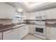 The kitchen has a window above the sink and white appliances at 139 Bluff View Dr # 405, Belleair Bluffs, FL 33770