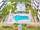 Aerial view of a community pool with surrounding lounge chairs, palm trees, and walkways at 139 Bluff View Dr # 405, Belleair Bluffs, FL 33770