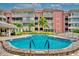 Community pool surrounded by landscaping and low rise residential buildings at 139 Bluff View Dr # 405, Belleair Bluffs, FL 33770