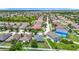 Aerial view of a quiet residential neighborhood, highlighting lush greenery, a pond, and well-maintained homes at 14371 Edinburgh Moor Dr, Wimauma, FL 33598