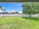 Large, fenced backyard with mature tree and green grass at 14371 Edinburgh Moor Dr, Wimauma, FL 33598