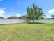 Lush backyard with mature tree and white vinyl fence at 14371 Edinburgh Moor Dr, Wimauma, FL 33598