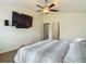 Relaxing bedroom with ensuite access and a mounted television at 14371 Edinburgh Moor Dr, Wimauma, FL 33598