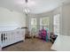 Bedroom features a crib, chandelier and rocking chair at 14371 Edinburgh Moor Dr, Wimauma, FL 33598