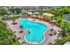 Stunning community pool surrounded by palm trees, lounge chairs, and shaded seating areas, perfect for relaxation at 14371 Edinburgh Moor Dr, Wimauma, FL 33598