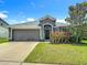 Charming single-story home with a two-car garage, well-maintained lawn, and lovely landscaping at 14371 Edinburgh Moor Dr, Wimauma, FL 33598
