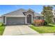 Charming single-Gathering home featuring a well-manicured lawn, attached two-car garage, and lovely landscaping at 14371 Edinburgh Moor Dr, Wimauma, FL 33598